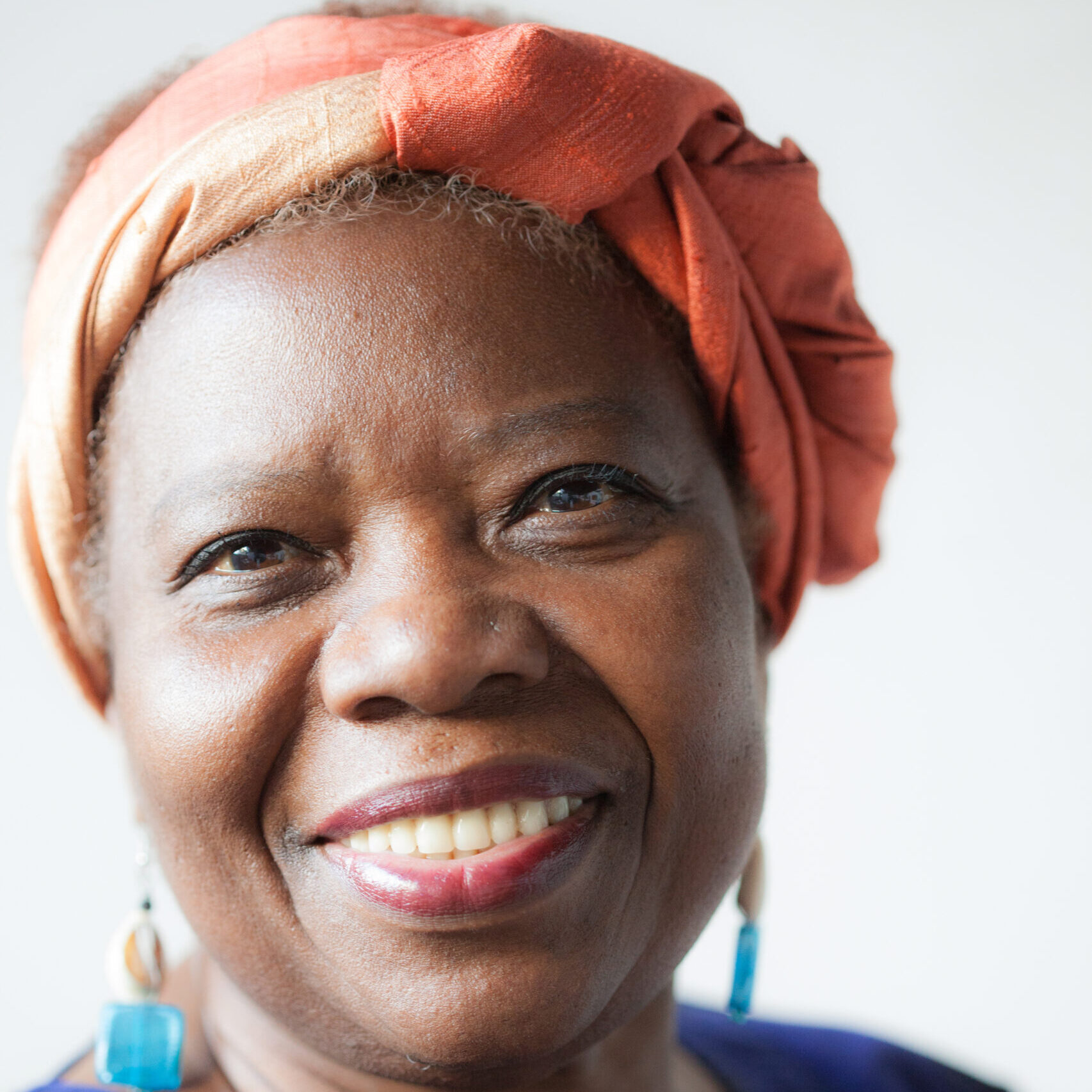 Cheryl Boyce-Taylor wearing an orange headwrap and turquoise earrings
